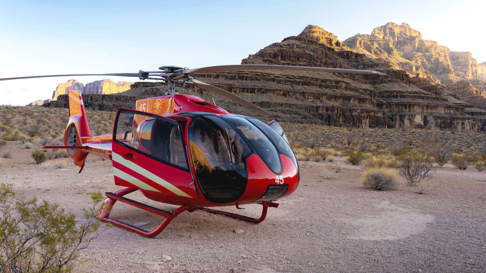 A red helicopter landed at the bottom of the Grand Canyon.