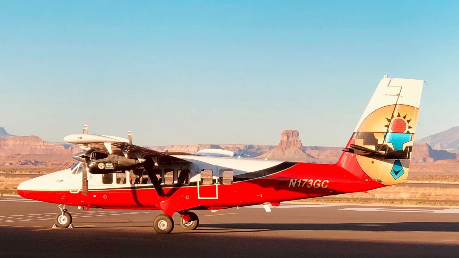 a touring airplane parked at the page az airport with tower butte in the background
