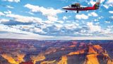A small plane flying over the south rim of Grand Canyon.
