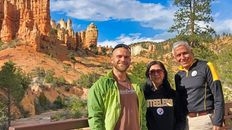 Group of people taking pictures in front of bryce canyon rock features.