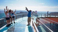 A family taking a picture on the Skywalk Bridge located at Grand Canyon West.