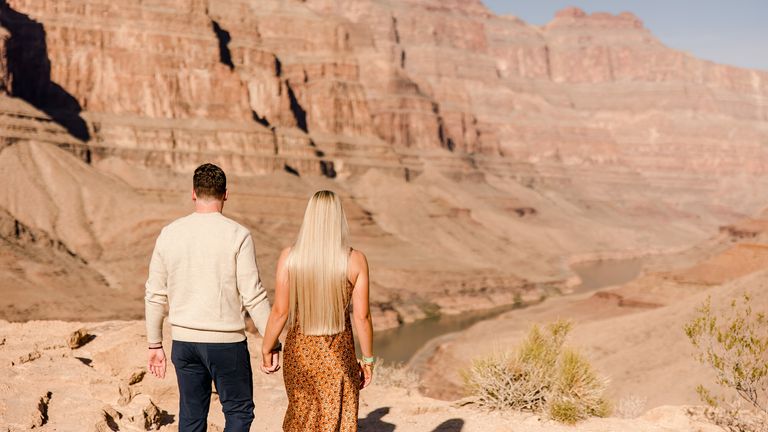 Couple walking near the river at the bottom of the grand canyon