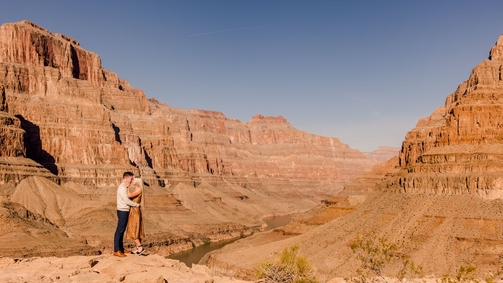 a Las Vegas helicopter tour couple embraces at the bottom of the Grand Canyon