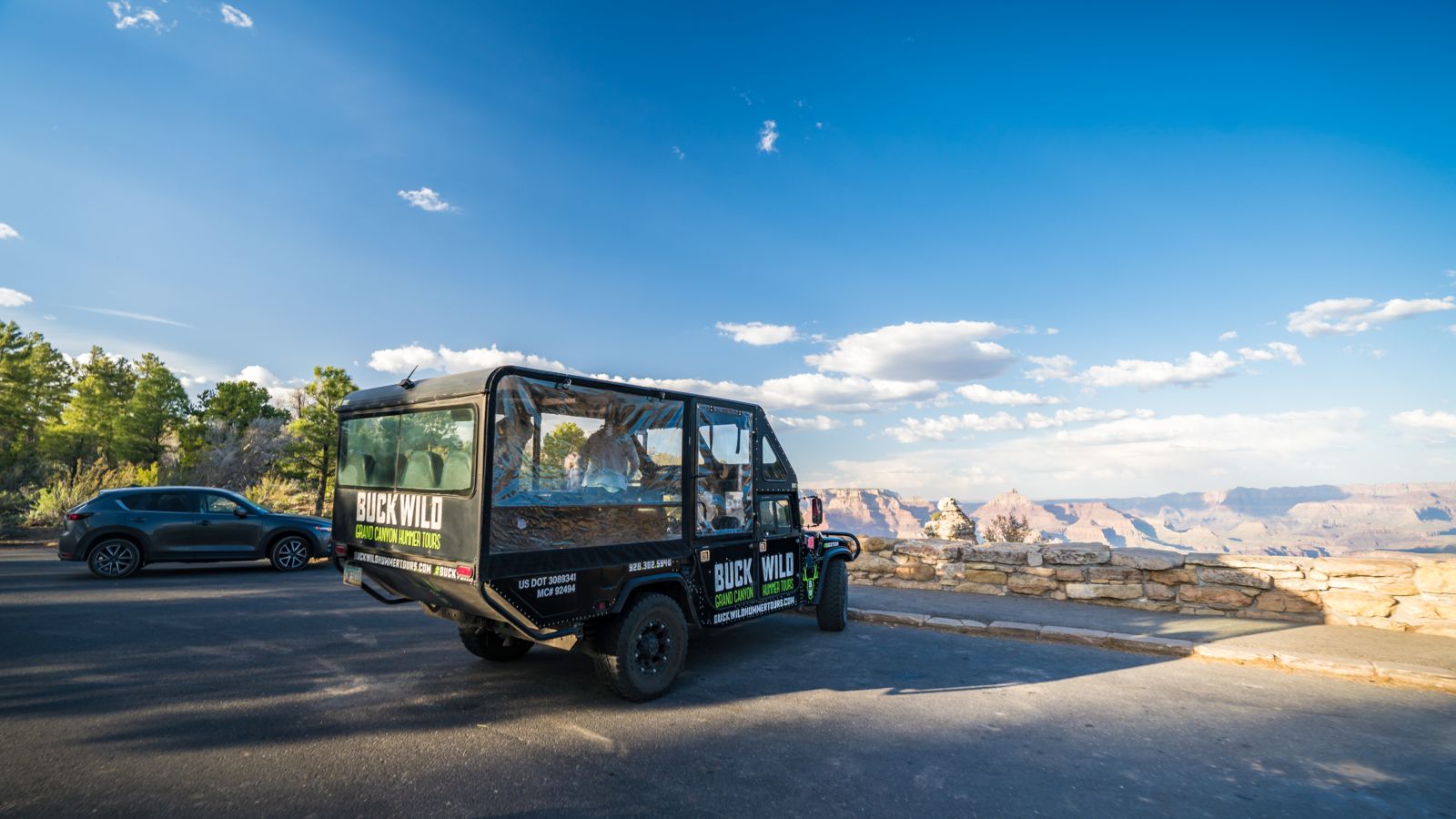 a Grand Canyon hummer tour parked at the edge of a Grand Canyon lookout point