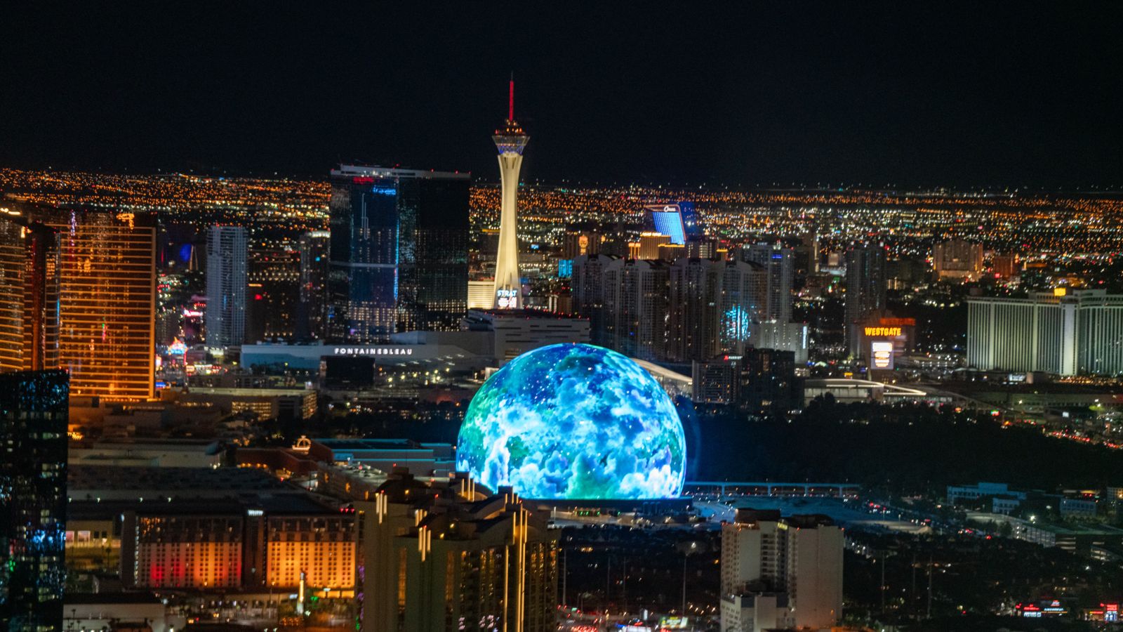 Aerial views of illuminated MSG Sphere from a helicopter