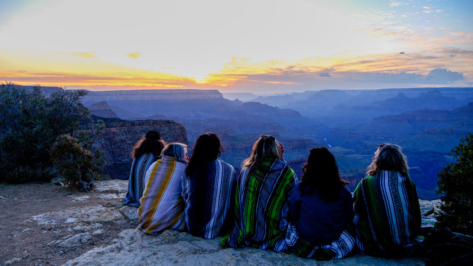 Hummer tour guests enjoy a Grand Canyon sunset with blankets included in their vehicle