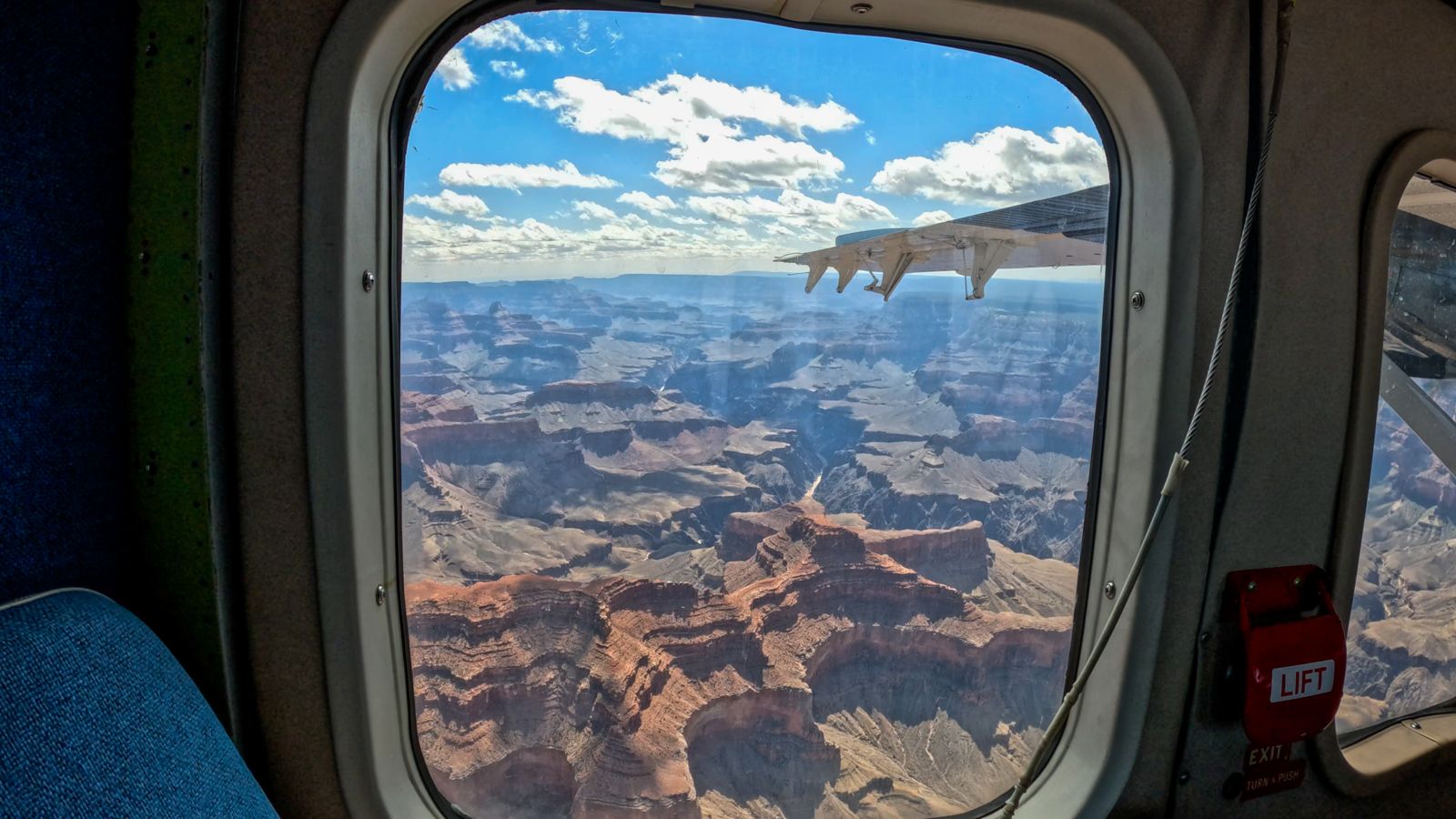a view of the Grand Canyon South Rim seen from the window of an airplane tour