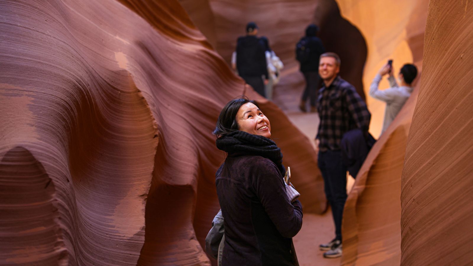 visitors on an Antelope Canyon tour walk between the giant sandstone walls