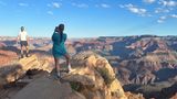 Two hikers take photos at the edge of the Grand Canyon on Grandview Trail