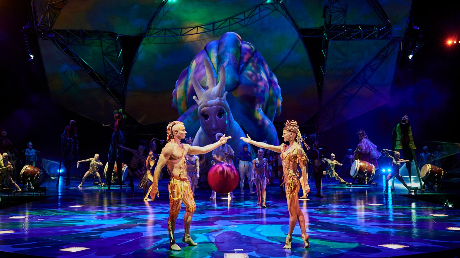 Two members of Cirque du Soleil Mystere stand onstage about to hold hands
