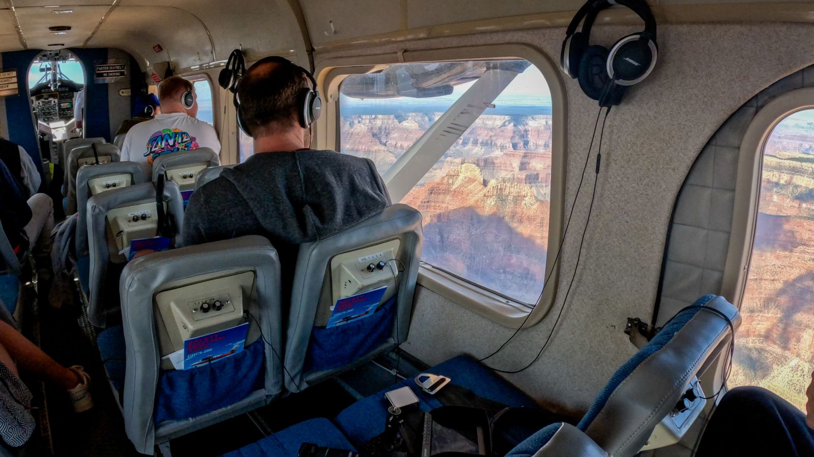 Passengers on a Grand Canyon airplane tour gaze at the views out the window