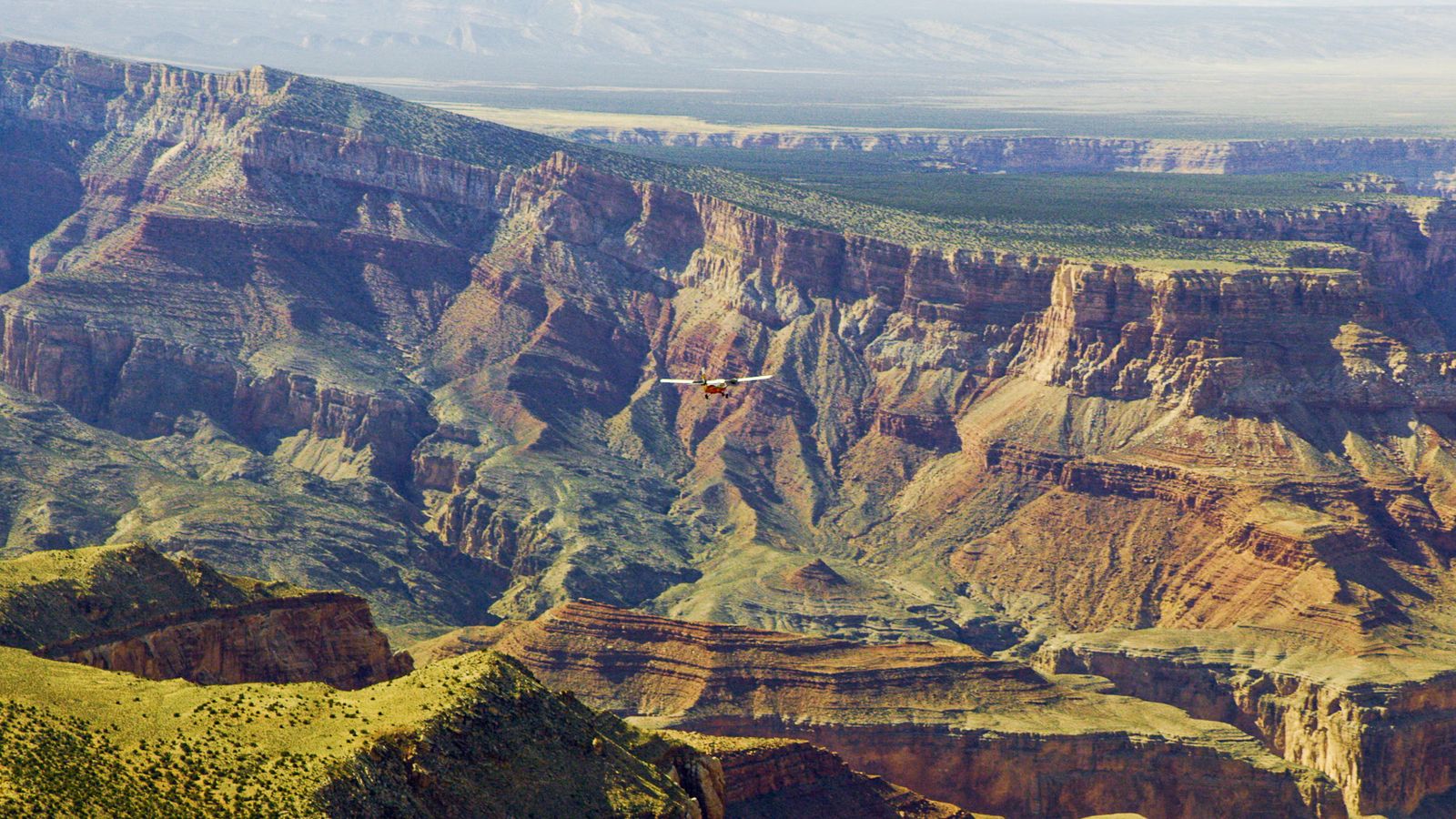 A Twin Otter touring airplane seen in front of unique Grand Canyon rock formations