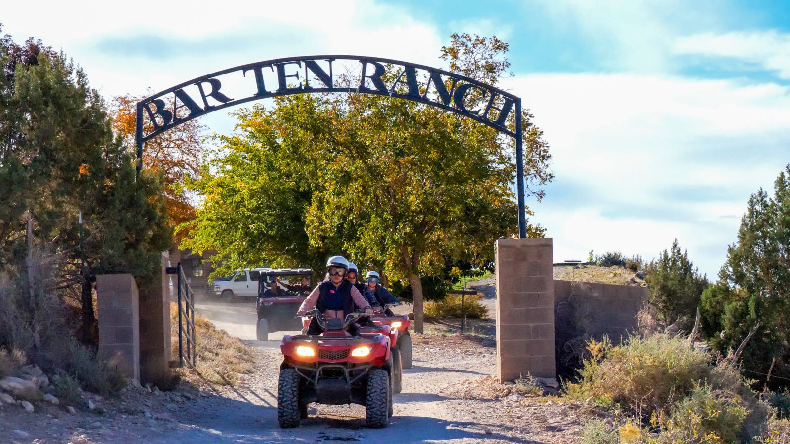 An ATV vehicle driving under the Bar 19 Ranch entry sign