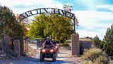 An ATV vehicle driving under the Bar 19 Ranch entry sign