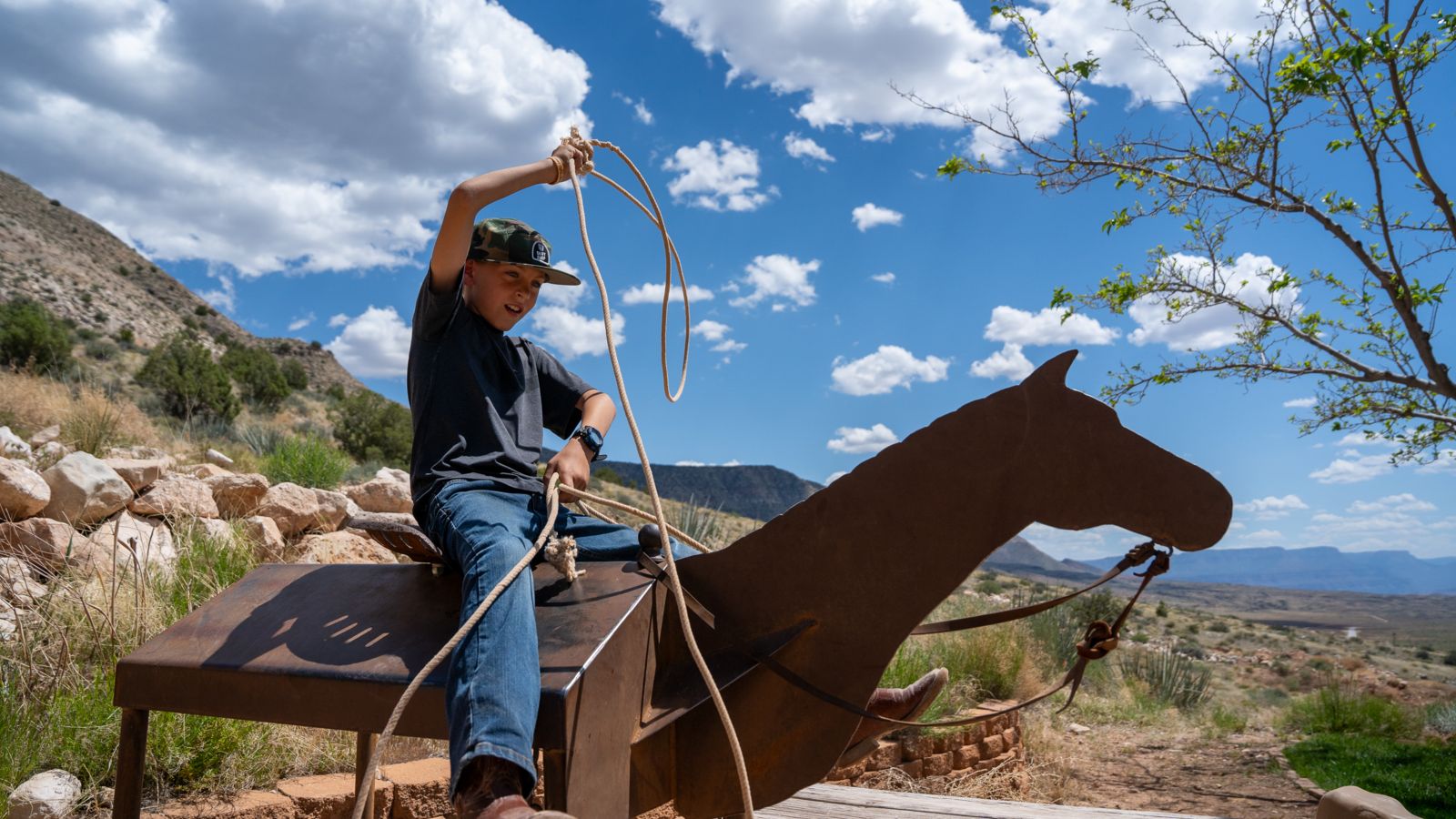 A child learning how to lasso during a visit to Bar 10 Ranch