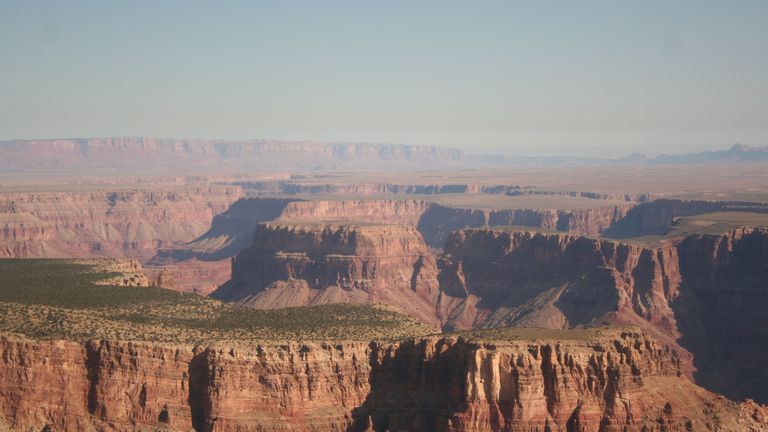 The Grand Canyon seen in sunny weather with a misty fog over the walls.