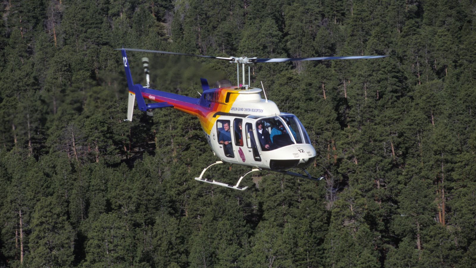 Bell helicopter flying over the Kaibab Forest near Grand Canyon National Park