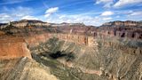 Lush green forestry is displayed across a Grand Canyon landscape on a sunny day