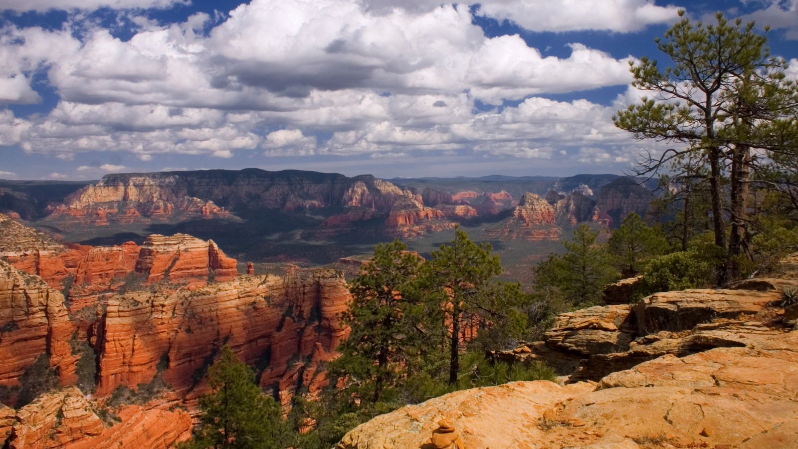 red rock formations found in Sedona, Arizona below a clouded sky