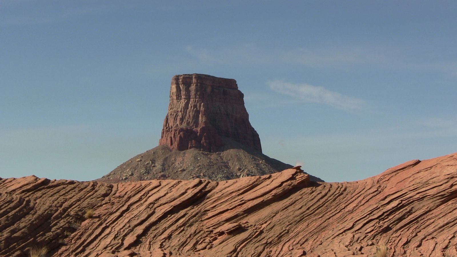 Ground view of the colossal Tower Butte rising from the expanse of the Arizona desert