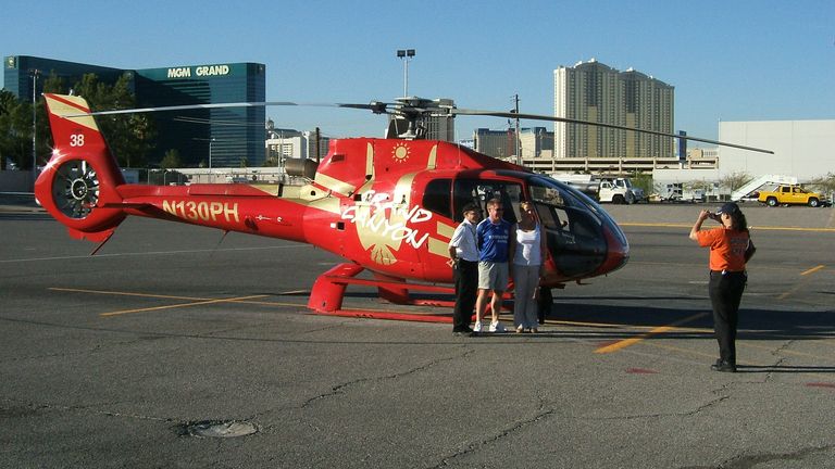 passengers for a Grand Canyon helicopter tour stand on the tarmac and take pictures