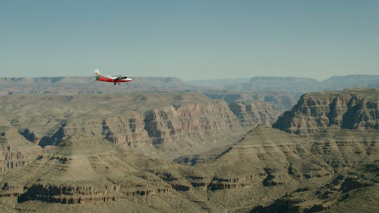 a Grand Canyon airplane tour flies over the West Rim in a clear sky