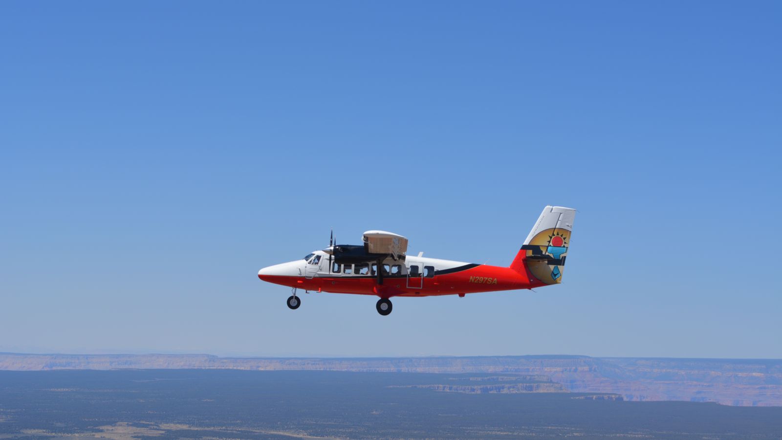 A Airlines Vistaliner aircraft flies from Las Vegas to the Grand Canyon West in a bright clear sky