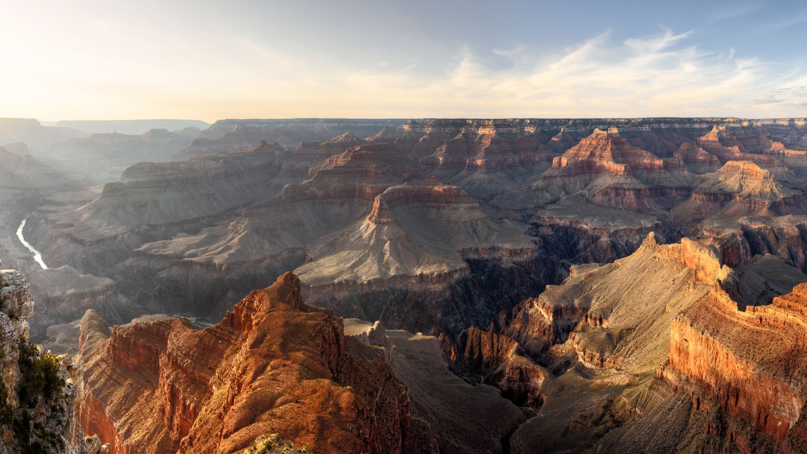 View of the Grand Canyon South Rim with the sun shining from the left side and the Colorado River seen below.