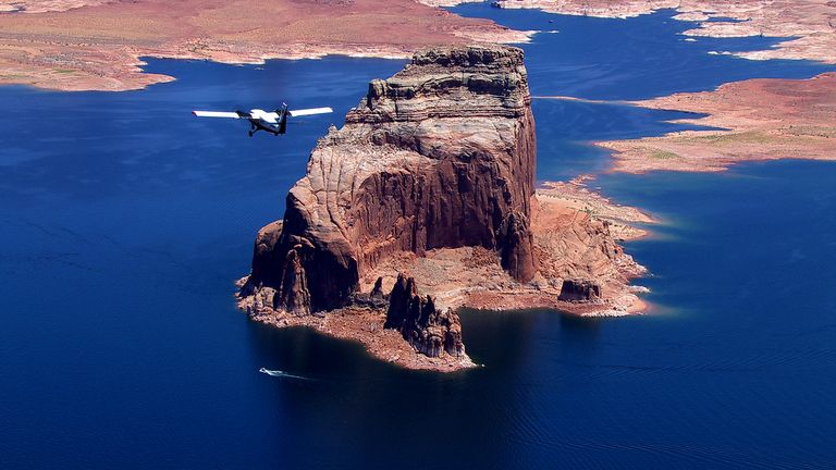 a sightseeing airplane tour flies over the blue waters of lake powell