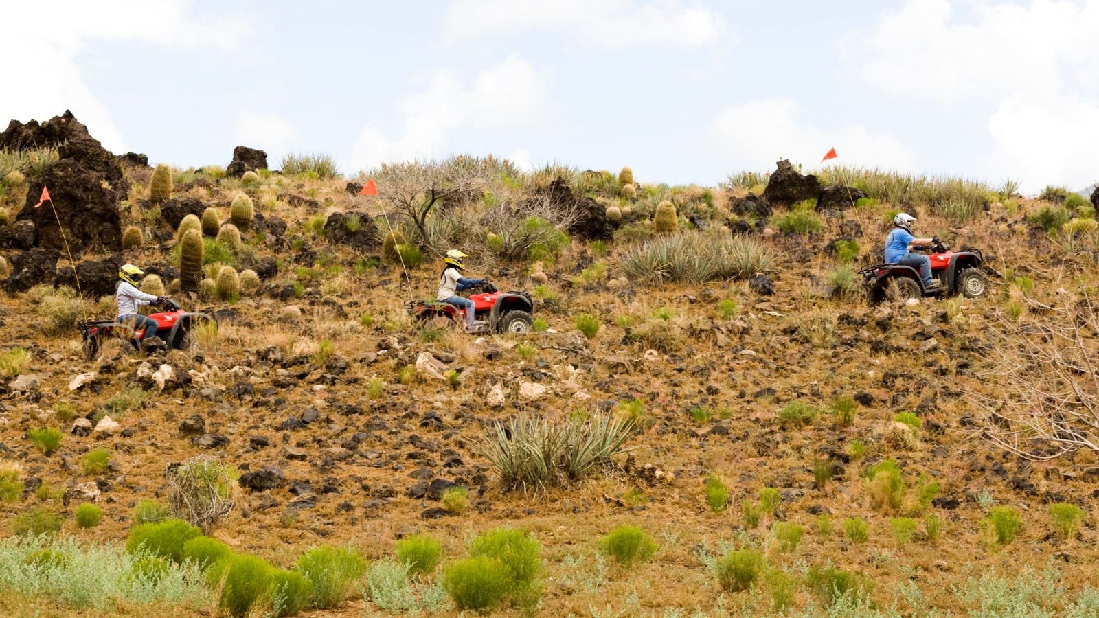 three passengers aboard ATVS drive through the canyon scenery