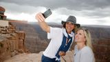 a group of visitors pose for a picture at the grand canyon west in front of the skywalk bridge