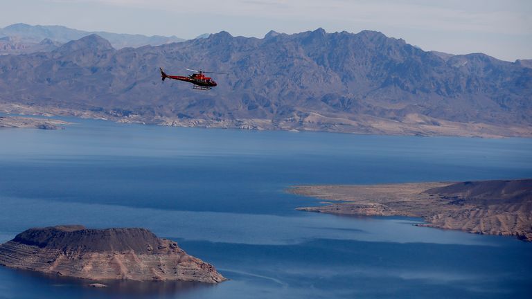 A red helicopter flies over Lake Mead en route to a Grand Canyon tour.