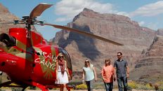 A tour group exits from a helicopter at the bottom of Grand Canyon.