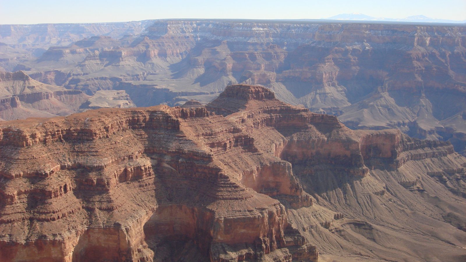 the striped sandstone walls of the grand canyon seen from an airplane tour