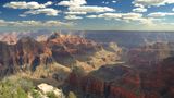 Golden sunshine casts rays across the striped walls of the Grand Canyon South Rim