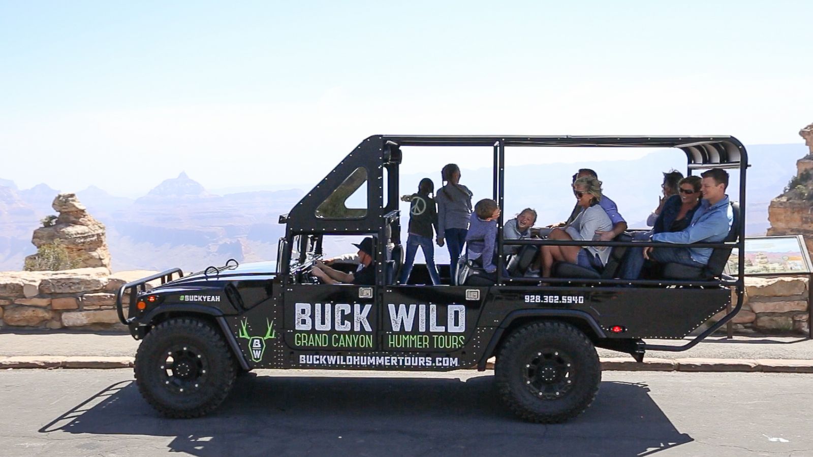 hummer with passengers on edge of grand canyon south rim on a sunny day