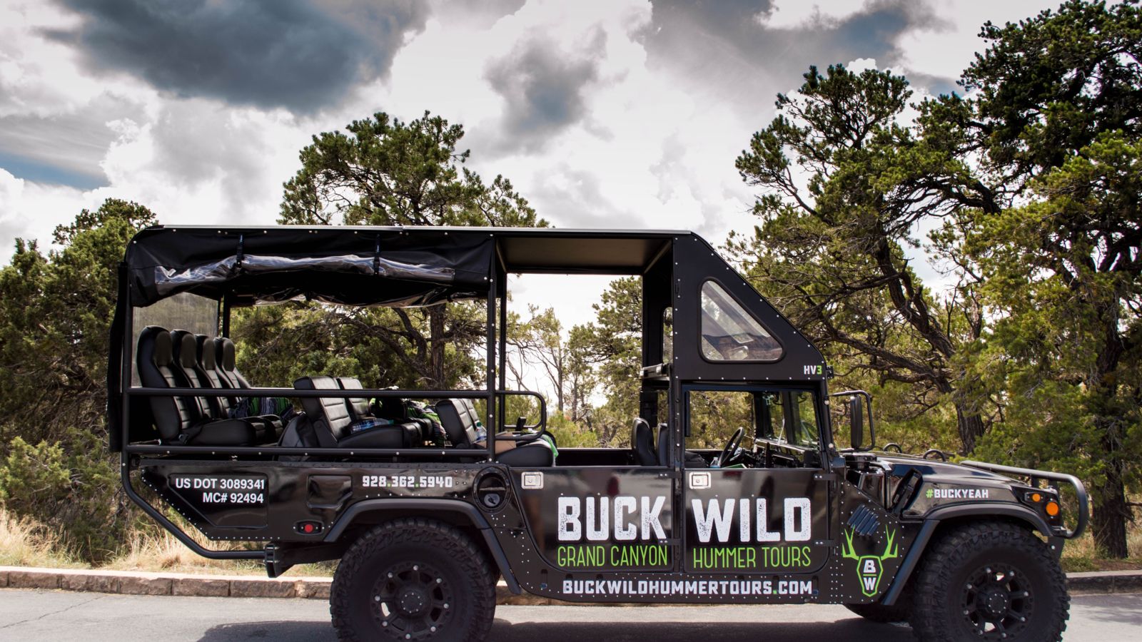 a grand canyon hummer vehicle parked at the edge of the grand canyon