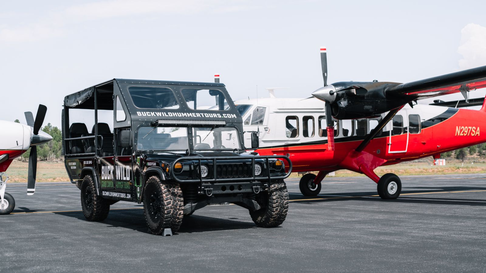 The Grand Canyon National Park tarmac featuring a Papillon helicopter and a Buck Wild Hummer