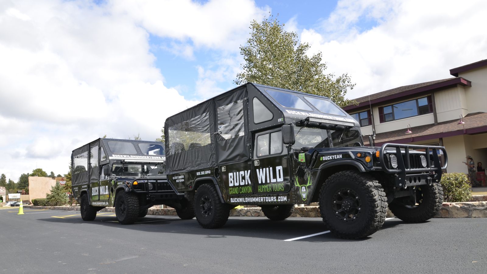 two open-air hummer tour vehicles parked at the south rim depot