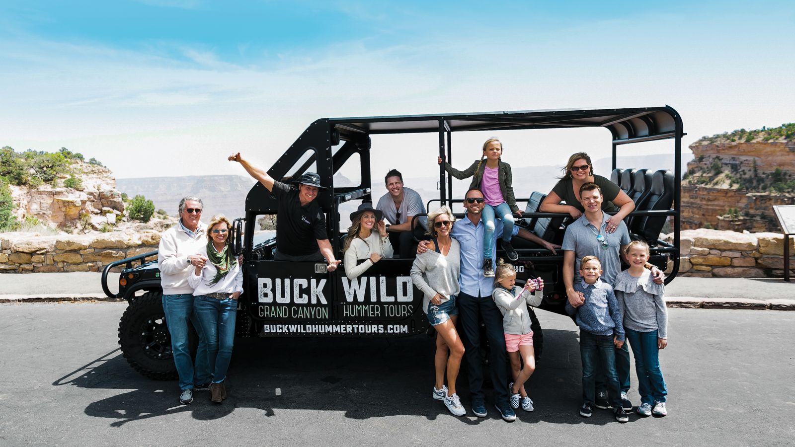 a family poses aboard a hummer touring vehicle at the grand canyon