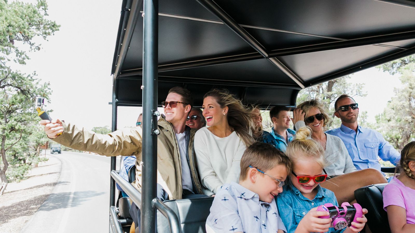 a tour group smiles and takes photos aboard a grand canyon hummer tour