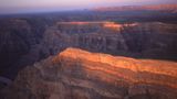 The striped walls of the Grand Canyon West seen from the sky at sunset.