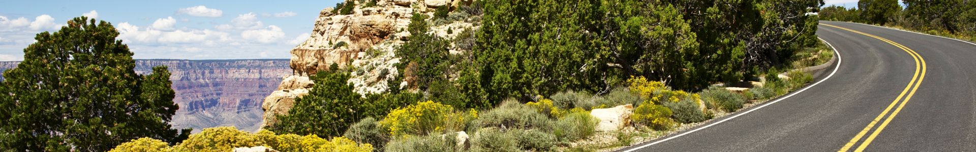 a paved road cuts along the edge of the Grand Canyon
