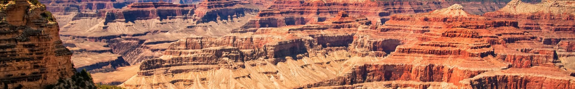 the bright orange and red walls of the Grand Canyon seen on a sunny day