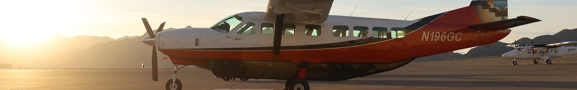 A Cessna Caravan sightseeing airplane parked on the tarmac at the Boulder City air terminal.