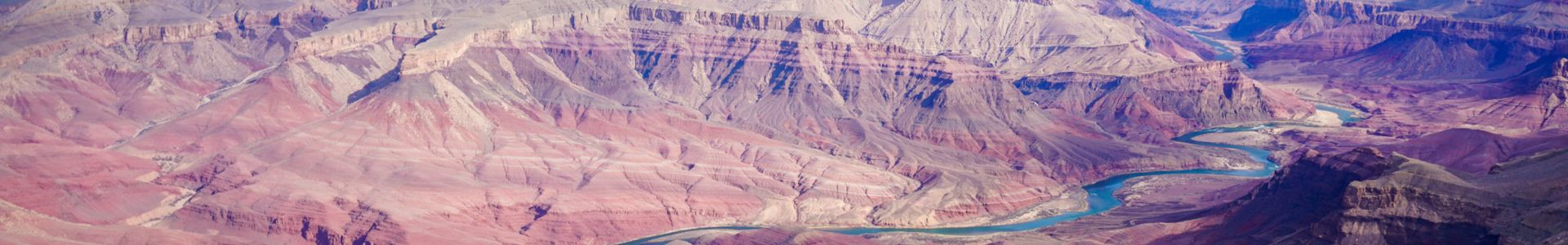 A broad view of the Grand Canyon walls and the blue Colorado River winding between them