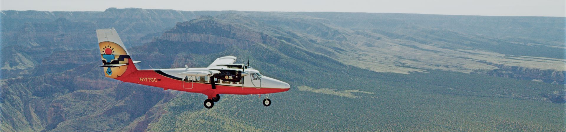 A Twin Otter touring airplane flies over the Kaibab Forest