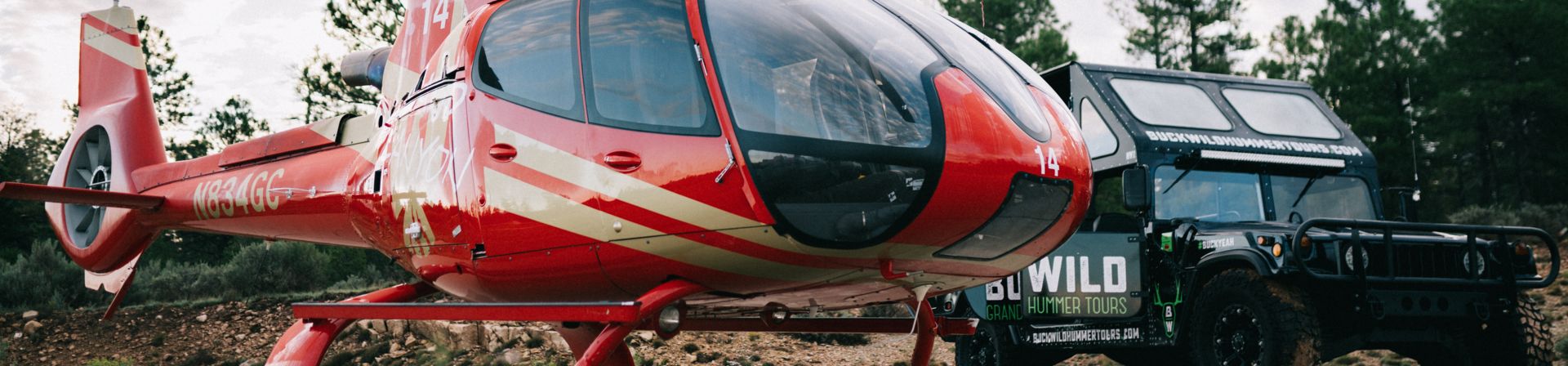 A Buck Wild Hummer and a Papillon Helicopter parked together