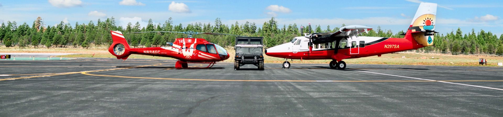 A Papillon helicopter and a Buck Wild Hummer parked the Grand Canyon National Park