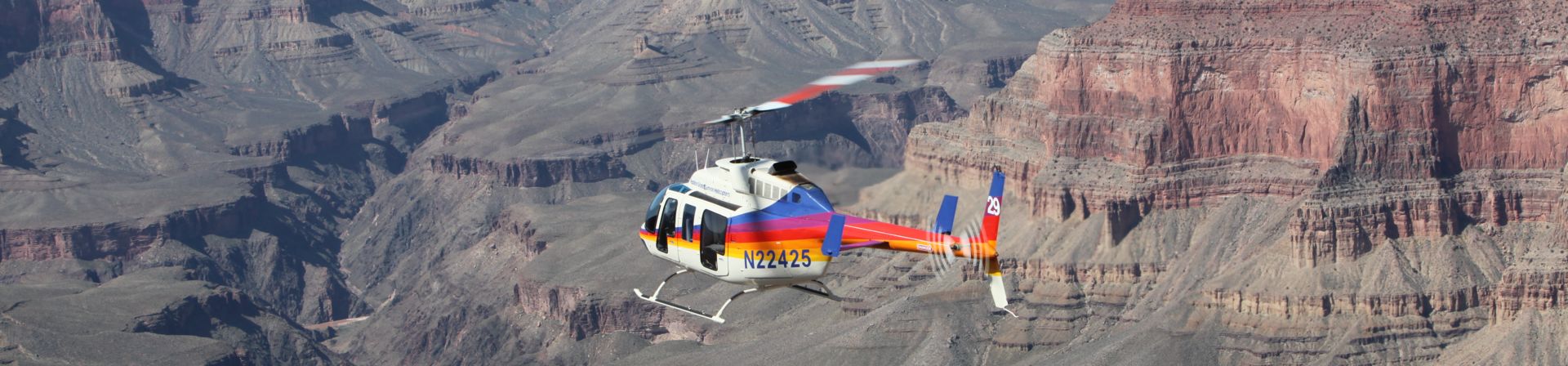 A sightseeing helicopter tour flies over the Colorado River at the Grand Canyon National Park